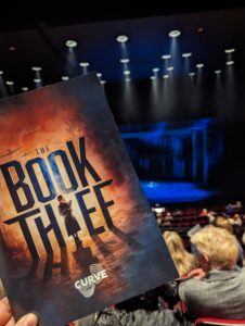 Cp[y of the programme for The Book Thief musical with the stage behind it.